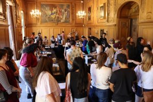 Photograph of the Clark Library's Drawing Room with attendees perusing books and rare materials at the 2023 Open House