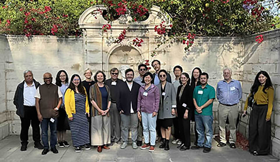 Group of scholars standing in the Clark Library Outdoor Reading Room.