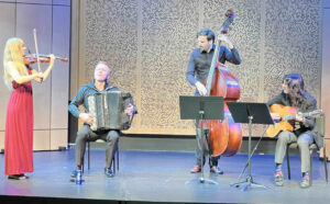 Photo of four musicians playing on a stage.